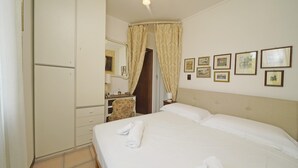 A hotel room with a bed, a wardrobe, a desk, and a bathroom. - Appartamento Balander (Sirmione)