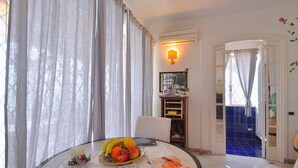 A dining area with a table set for two, featuring a fruit bowl and a magazine. - Villa With Terrace and sea View in Ravello ID 3196 (Ravello)