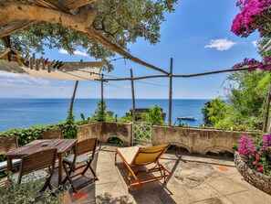 A patio with wooden furniture, a view of the sea, and a pergola structure. - Villa With Terrace and sea View in Ravello ID 3196 (Ravello)