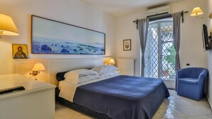 A hotel room with a bed, bedside lamps, a painting, a chair, and a view through the window. - Villa With Terrace and sea View in Ravello ID 3196 (Ravello)