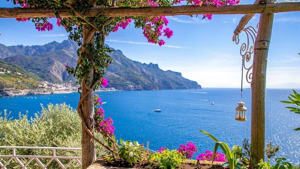 A wooden pergola with pink bougainvillea flowers, overlooking a coastal sea with boats and mountains in the background. - Villa With Terrace and sea View in Ravello ID 3196 (Ravello)