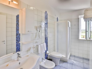 A modern bathroom with a large mirror, white sink, bidet, toilet, and a shower area. - I Giardini Dell Olimpo - Zeus (Capaccio-Paestum)