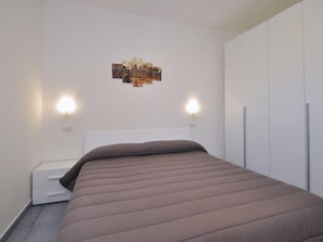 A bedroom with a bed, white wardrobe, and wall-mounted lights. - I Giardini Dell Olimpo - Zeus (Capaccio-Paestum)