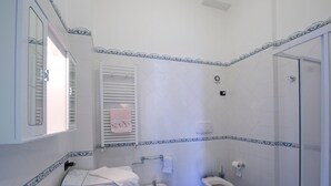 A bathroom with a sink, bidet, toilet, and a shower area. - Appartamento a Vietri sul Mare ID 3048 (Vietri sul Mare)