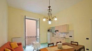 A compact living space with a dining area, kitchenette, and a balcony. - Appartamento a Vietri sul Mare ID 3055 (Vietri sul Mare)
