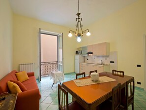 Ein kompakter Wohnbereich mit Essbereich, Küchenzeile und Balkon.
