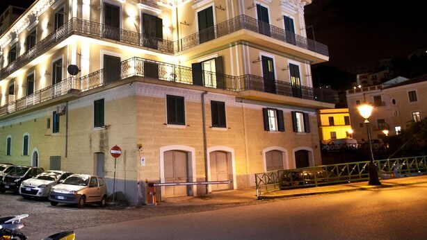 A multi-story building with balconies, a gated entrance, and parked cars. - Appartamento a Vietri sul Mare ID 3056 (Vietri sul Mare)
