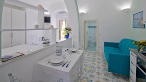 Un espace de vie compact comprenant un coin repas, une cuisine et une salle de bain.