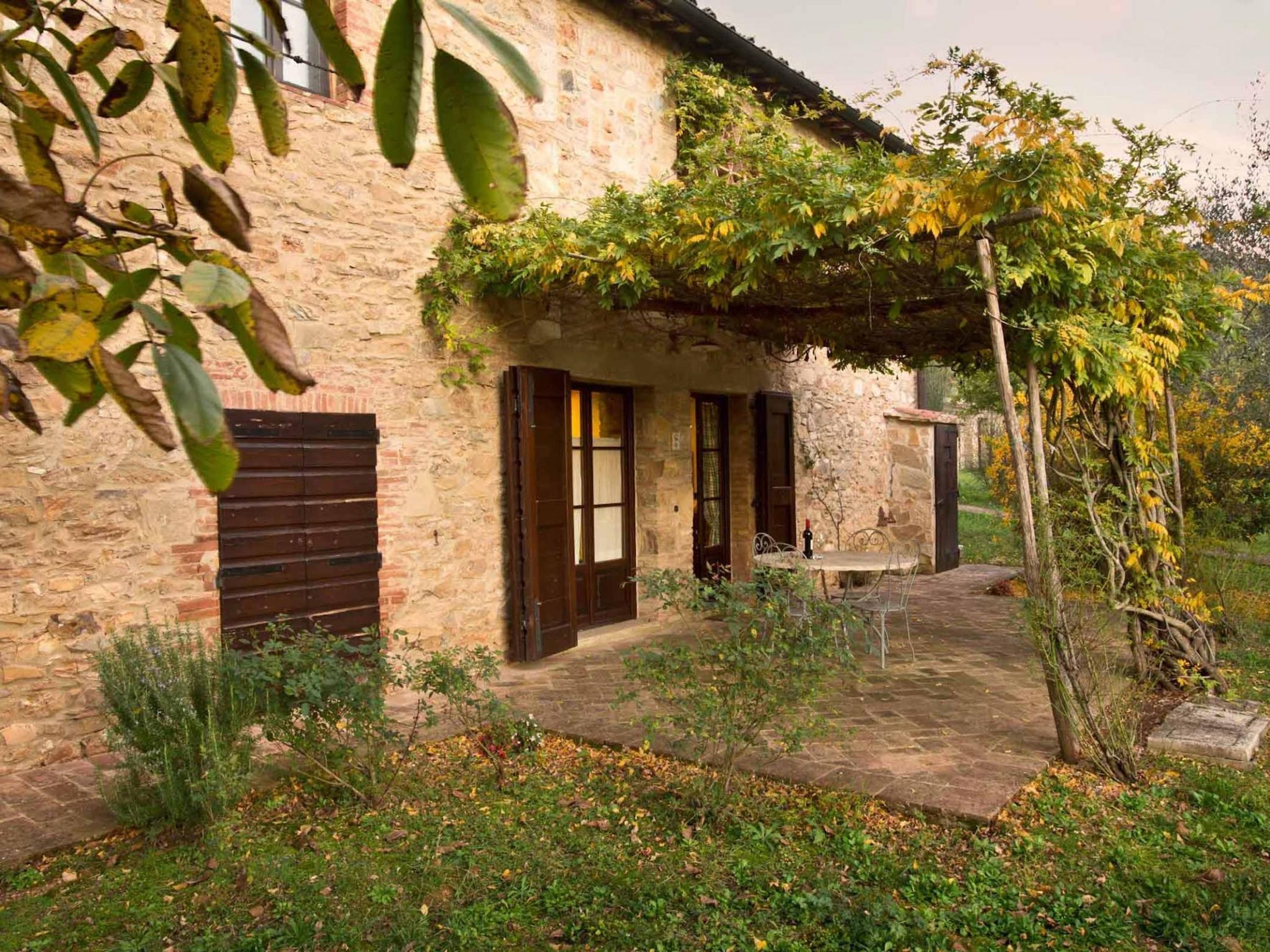 A stone building with a covered patio and a garden.