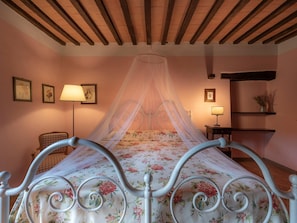 A bedroom with a four-poster bed, floral bedding, a canopy, and a nightstand with a lamp. - Country House a Casole d Elsa ID 451 (Casole d'Elsa)