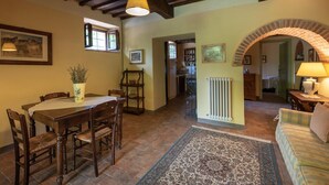 A dining area with a wooden table and chairs, a rug, and a hanging light fixture. - Country House a Casole d Elsa ID 451 (Casole d'Elsa)