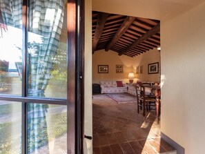 Cozy space with a traditional touch, featuring a wooden ceiling, patterned tiles, and a comfortable seating area with a sofa and dining table.