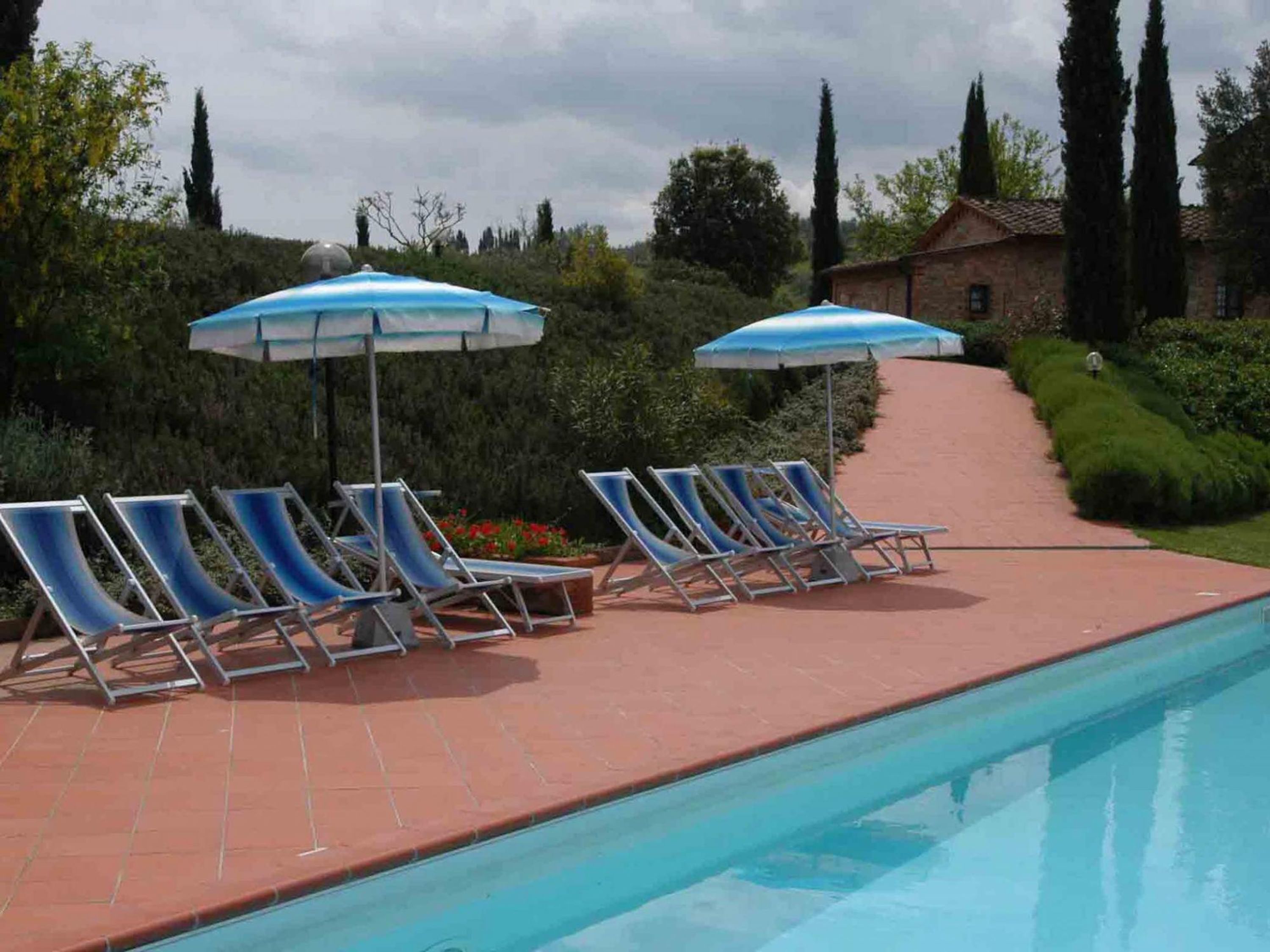 Una piscina con sillas de descanso y sombrillas.