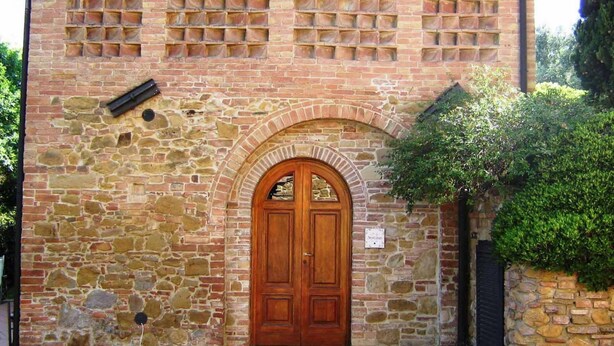 Ein Steinhaus mit Holztür und Bogenportal.
