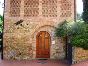 Un edificio in pietra con una porta in legno e un ingresso ad arco.