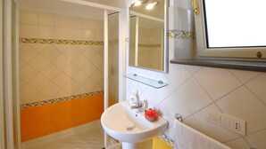 A bathroom with a shower, a sink, a mirror, and a towel rack. - Relais San Basilio Convento - ID 3061 (Amalfi)
