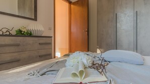 A bedroom with a bed, a dresser, a mirror, and a door.