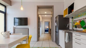 Una cocina moderna con refrigerador, pileta y comedor con mesa y sillas.