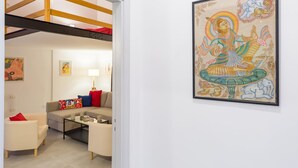 Un salon moderne avec un canapé, une table basse et un tableau représentant une créature mythique.