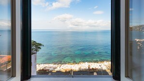 A seaside view from a window, including a rocky shoreline and a clear sky. - Terrazza Morgera in Napoli (Casamicciola Terme)