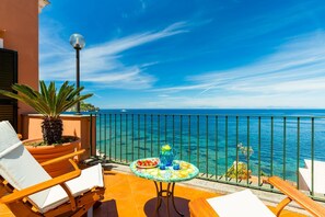 A balcony with a table set for two, overlooking a clear blue sea. - Terrazza Morgera in Napoli (Casamicciola Terme)