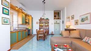 A compact living space with a kitchen, dining area, and a sofa. - Terrazza Morgera in Napoli (Casamicciola Terme)