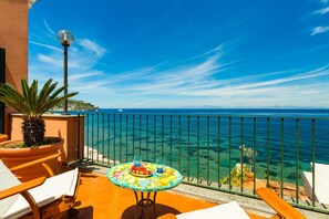 A balcony with a table set for two, overlooking a clear blue sea. - Terrazza Morgera in Napoli (Casamicciola Terme)