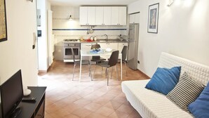 Um espaço compacto com cozinha compacta, área de refeições e sala de estar com cama.