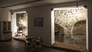 Un coin repas agrémenté d’une arche en pierre, d’une table avec des chaises et d’un buffet.