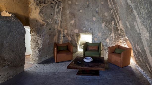 Un intérieur chaleureux avec deux fauteuils en cuir, une table basse et un mur en pierre.