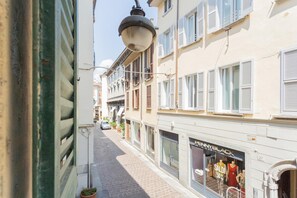 A narrow street with buildings on either side, a visible storefront with mannequins, and a clear sky. - Da Pia in Historycal Como City Centre (Como)