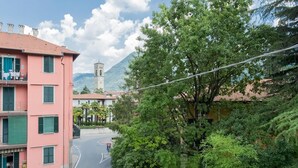 Eine Straße mit Gebäuden, einem Glockenturm und einem Berg im Hintergrund.
