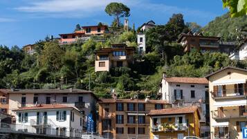 Una zona residencial en una ladera con edificios de varios pisos, balcones y un cielo azul despejado.