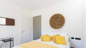 Ein Schlafzimmer mit einem Bett, einer runden Wanddekoration, einer Tür und einem Nachttisch.