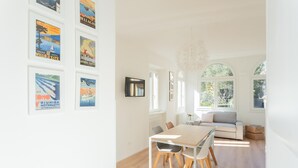 A bright dining area with a wooden table and chairs, a white sofa, and a chandelier. - Co-m341-sabb12a1 - Sunny Corner Near Bellagio (Tremezzina)