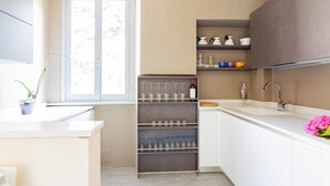 A modern kitchen with white cabinets, a built-in wine rack, and a window with a view.