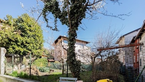 Eine Terrasse mit Tisch, einer Obstschale und einer Bank.