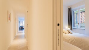 A hotel room with a bed, a window with curtains, a door, and a hallway leading to another room. - Co-e405-regi74a1 - Your Private Harbour Nearby George Clooney (Carate Urio)
