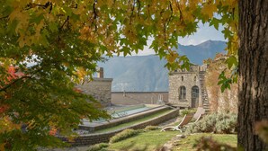 A stone building with a swimming pool, surrounded by trees and mountains in the background. - Co-d462-mpal3at - Villa Sunset Tower (Faggeto Lario)
