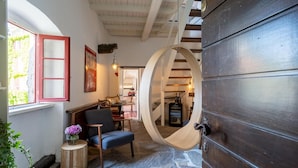 A cozy interior with a wooden door, a dining area, and a window with red frames.