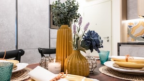 A dining table set with plates, a candle, and decorative vases.