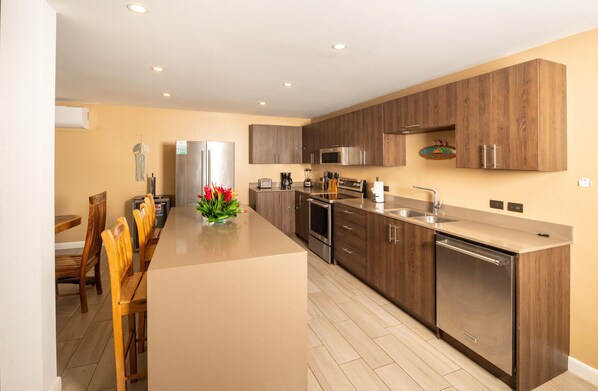 A modern kitchen with wooden cabinets, stainless steel appliances, and a central island with a vase of flowers.