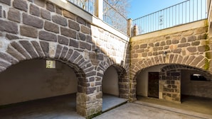 Ein gepflasterter Innenhof mit Rundbögen, einem Metallgeländer und einem Kachelboden.