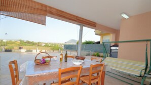A patio with a table set for dining, surrounded by chairs, a wicker basket, and a bowl. - Al080 Villa Stella Cinese con Piscina Privata (Alcamo)