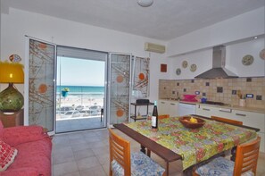 Enjoy a compact room with a balcony overlooking the beach, a dining area, and a small kitchen.