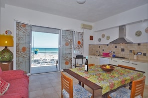 Enjoy a compact room with a balcony overlooking the beach, a dining area, and a small kitchen.