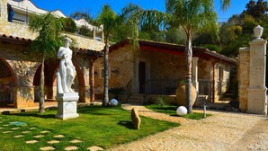 A courtyard with a statue, stone walls, and a paved path. - Dependance Desir e Piscina ad uso Esclusivo e Jac (Alcamo)