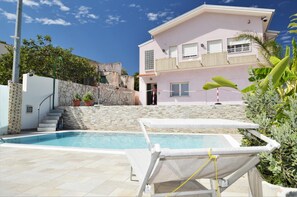 A two-story building with a swimming pool, outdoor seating, and a stone wall. - Villa Sweet Dream con Piscina Privata Riscaldata (Alcamo)