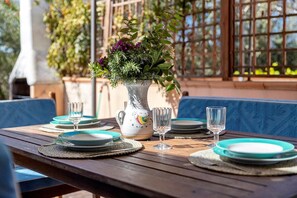 A table set with plates, glasses, and a decorative vase with flowers.