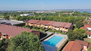 A residential area with a swimming pool, terraced houses, and a clear view of the surrounding landscape. - Casa Rudi in Sirmione (Sirmione)